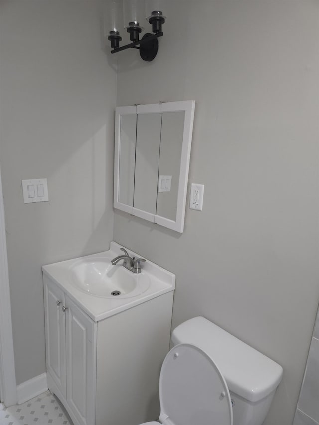 bathroom with a notable chandelier, vanity, and toilet