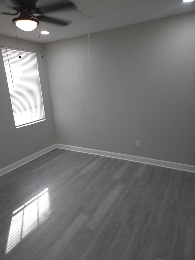 empty room with dark wood-style floors, attic access, and baseboards