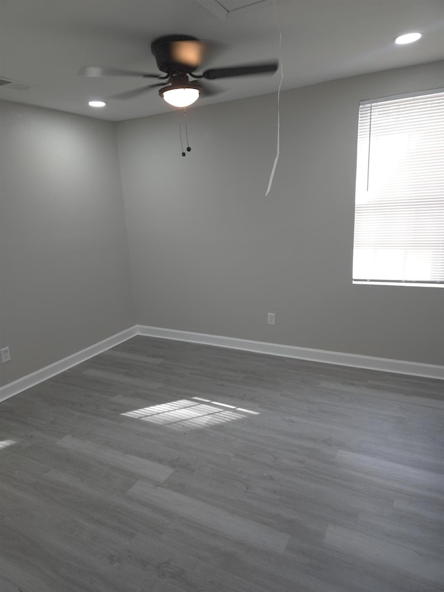 spare room with visible vents, wood finished floors, attic access, and baseboards