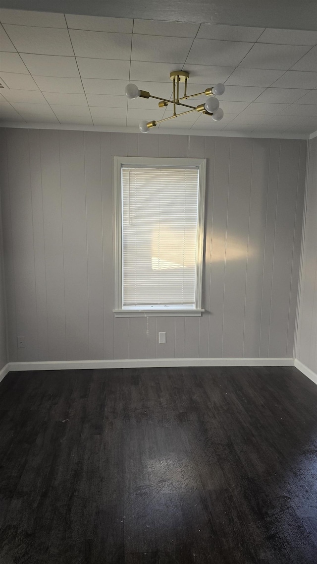 unfurnished room with dark wood-type flooring and baseboards