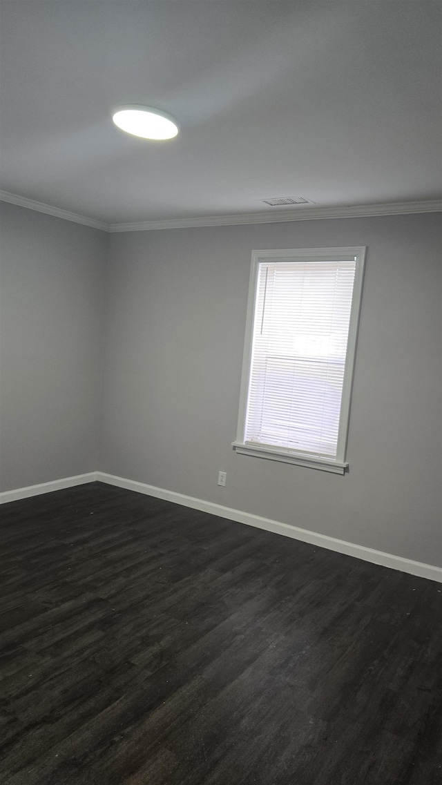 unfurnished room with dark wood finished floors, crown molding, and baseboards