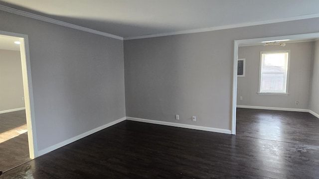 spare room with baseboards, dark wood finished floors, and crown molding