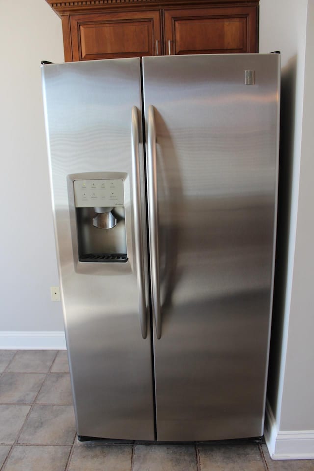 interior details with baseboards, brown cabinets, and stainless steel fridge with ice dispenser