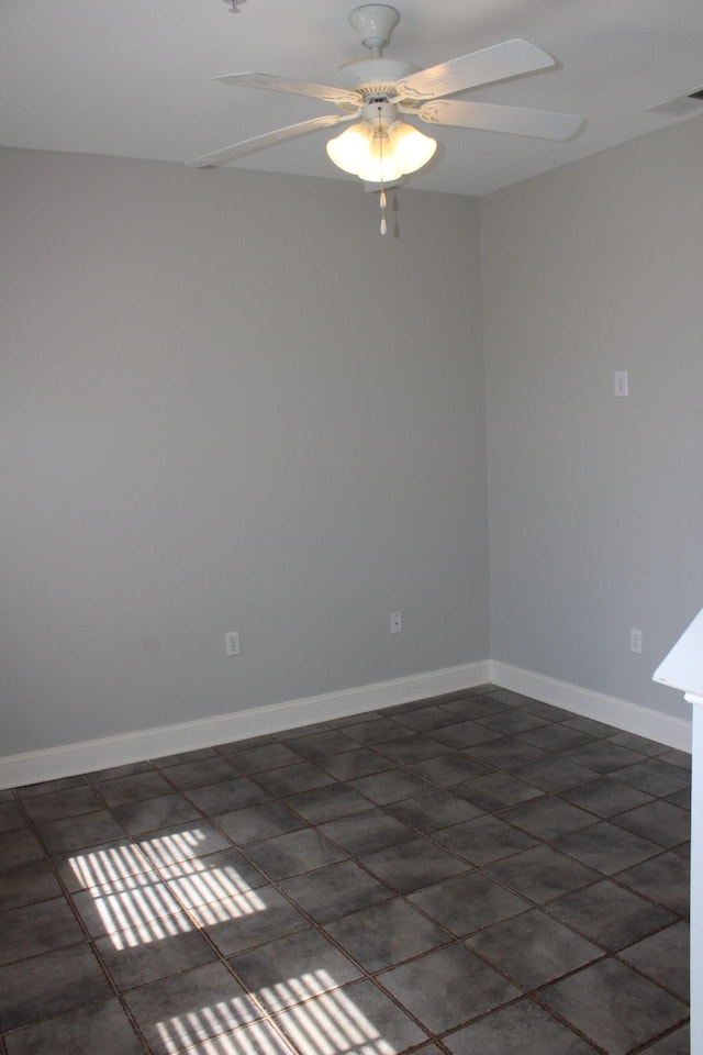 unfurnished room with a ceiling fan, visible vents, and baseboards