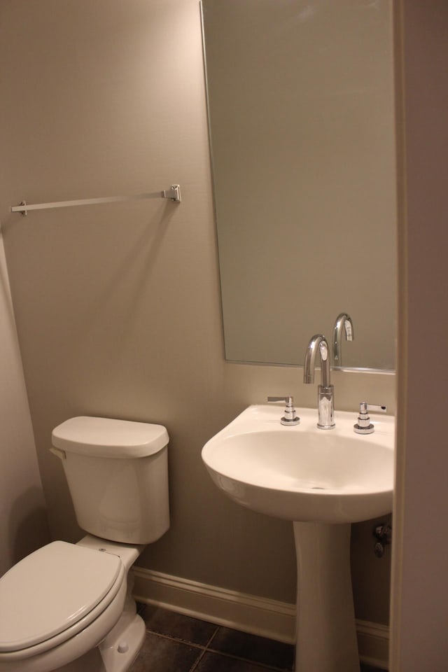 bathroom with tile patterned flooring, toilet, and baseboards