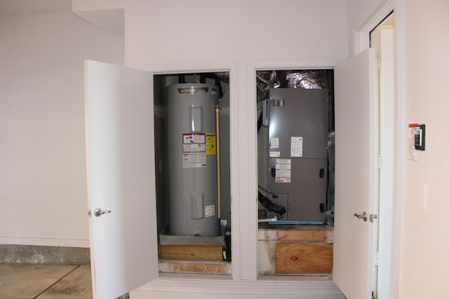 utility room with heating unit and water heater