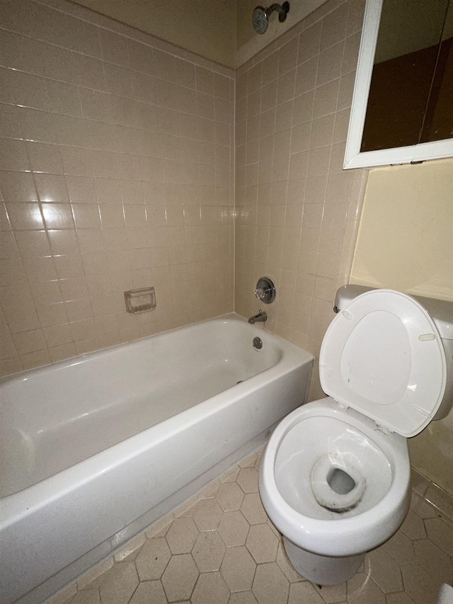 bathroom featuring toilet, bathtub / shower combination, and tile patterned floors