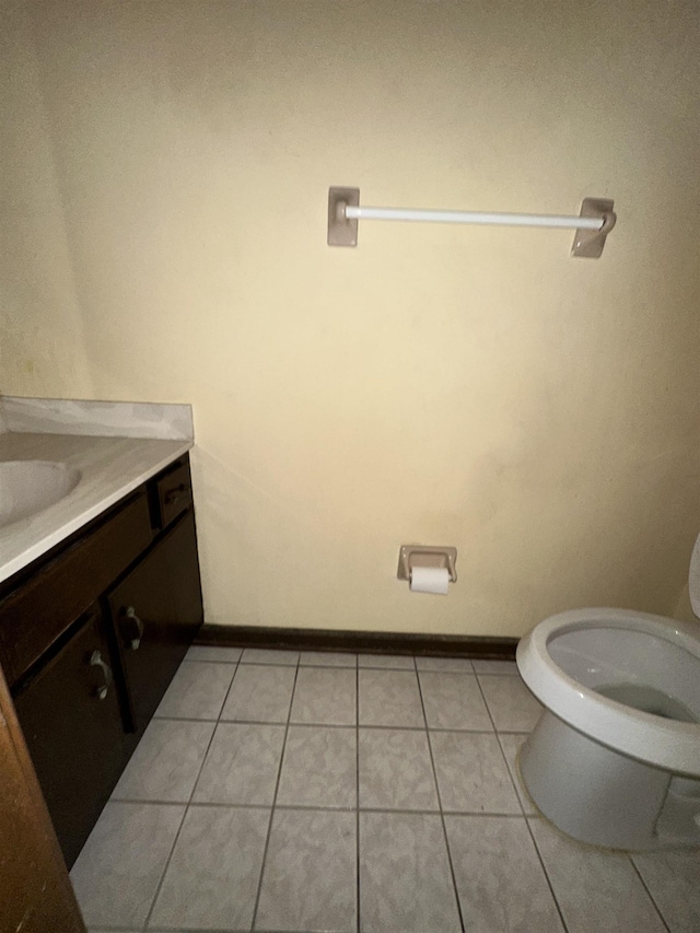 bathroom featuring tile patterned flooring, baseboards, vanity, and toilet