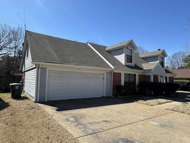 view of front of house featuring a garage, roof with shingles, concrete driveway, and brick siding