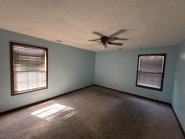 unfurnished room featuring carpet, visible vents, ceiling fan, a textured ceiling, and baseboards