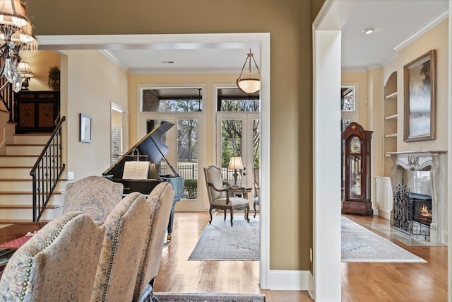 interior space featuring stairs, a high end fireplace, crown molding, and wood finished floors