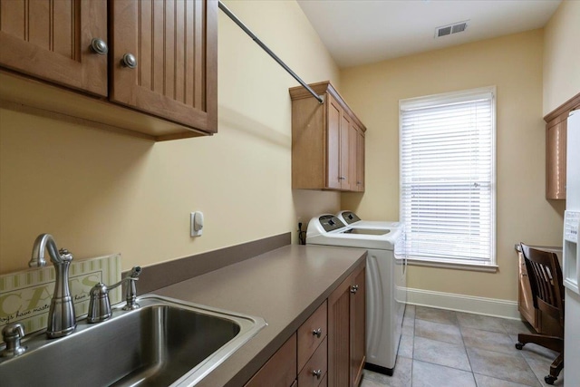 laundry room with a sink, visible vents, baseboards, independent washer and dryer, and cabinet space