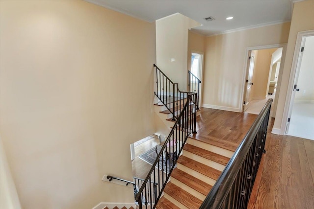 stairway featuring crown molding, recessed lighting, visible vents, wood finished floors, and baseboards