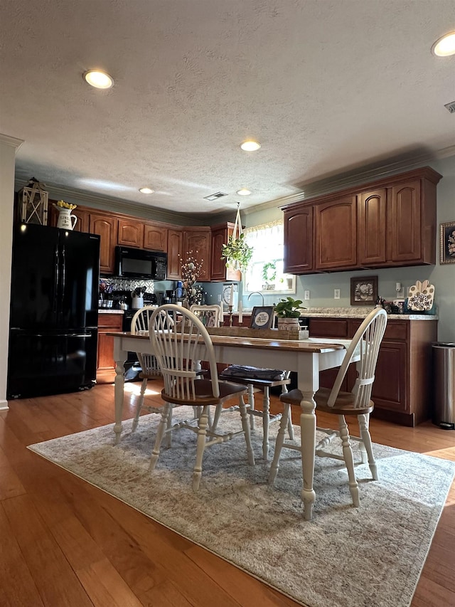 kitchen with black appliances, recessed lighting, light wood-style flooring, and crown molding