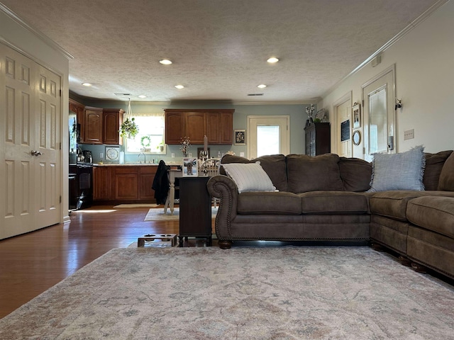 living room featuring a textured ceiling, dark wood finished floors, and crown molding