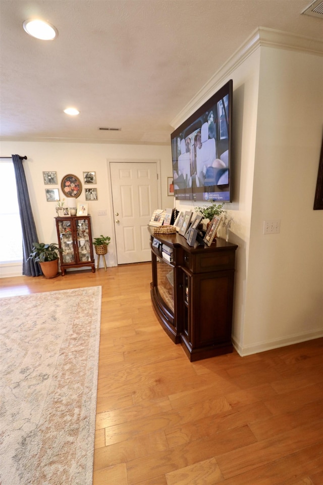 hallway featuring crown molding, recessed lighting, visible vents, light wood-type flooring, and baseboards