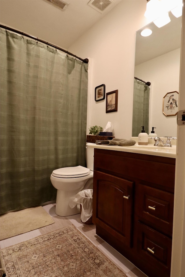 bathroom featuring visible vents, vanity, and toilet