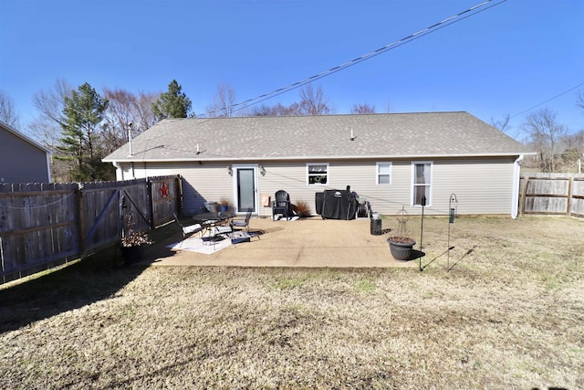 rear view of house with a patio area, a fenced backyard, a shingled roof, and a yard