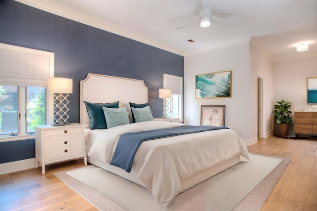 bedroom featuring light wood-type flooring, crown molding, baseboards, and ceiling fan