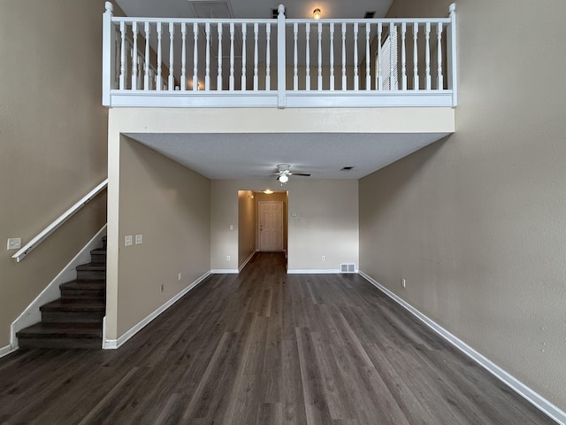 unfurnished living room featuring a ceiling fan, visible vents, baseboards, and wood finished floors