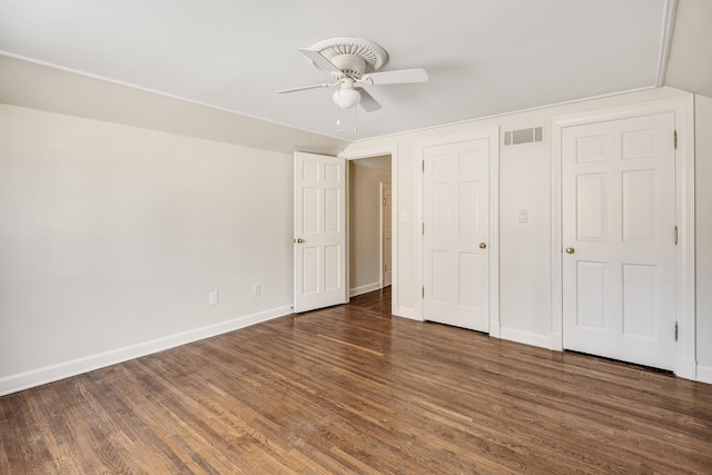 unfurnished bedroom featuring a ceiling fan, baseboards, visible vents, and wood finished floors