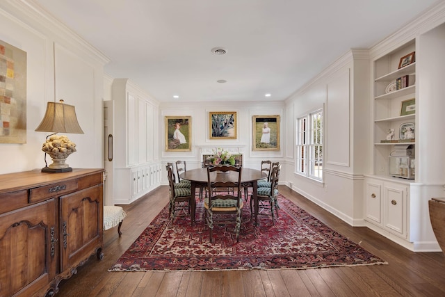 dining area with built in features, visible vents, a decorative wall, and dark wood-type flooring