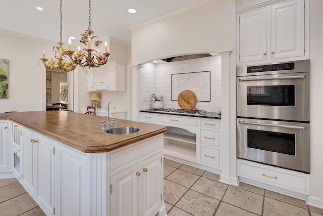 kitchen with crown molding, appliances with stainless steel finishes, backsplash, and a sink