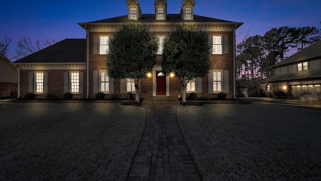 colonial inspired home featuring brick siding