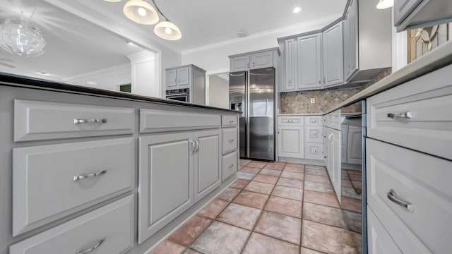 kitchen with appliances with stainless steel finishes, gray cabinets, crown molding, pendant lighting, and backsplash