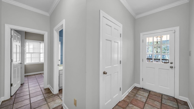 foyer with a healthy amount of sunlight, crown molding, and baseboards