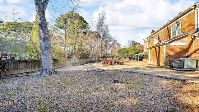 view of yard featuring central AC unit and fence