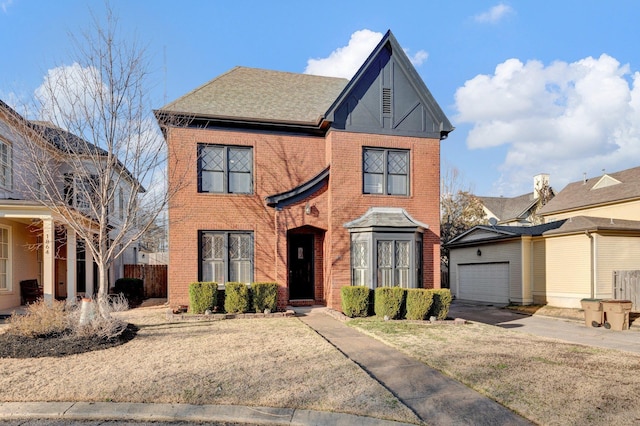 view of front facade with brick siding, roof with shingles, and an outdoor structure