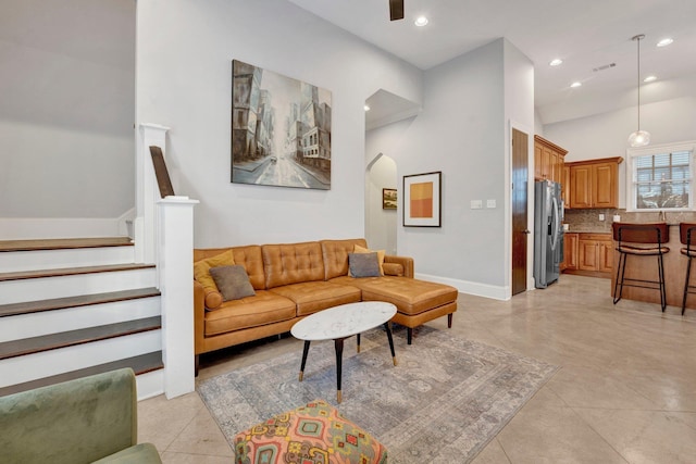 living area with light tile patterned flooring, baseboards, stairway, and recessed lighting