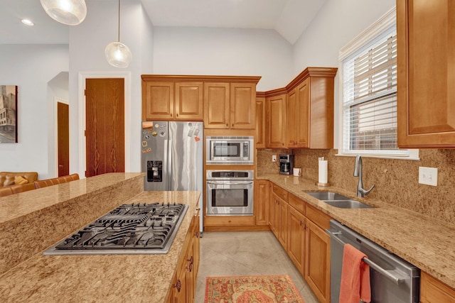 kitchen featuring light stone counters, light tile patterned flooring, a sink, appliances with stainless steel finishes, and backsplash