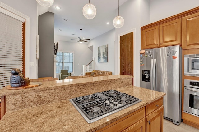 kitchen featuring a ceiling fan, appliances with stainless steel finishes, light stone counters, decorative light fixtures, and recessed lighting