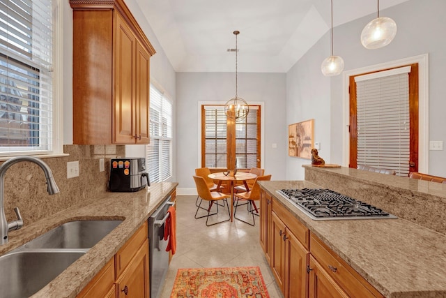 kitchen featuring a sink, appliances with stainless steel finishes, light stone countertops, tasteful backsplash, and pendant lighting