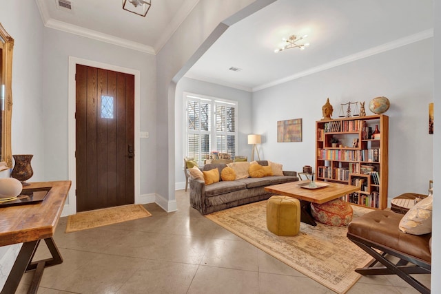 foyer entrance with arched walkways, visible vents, crown molding, and baseboards