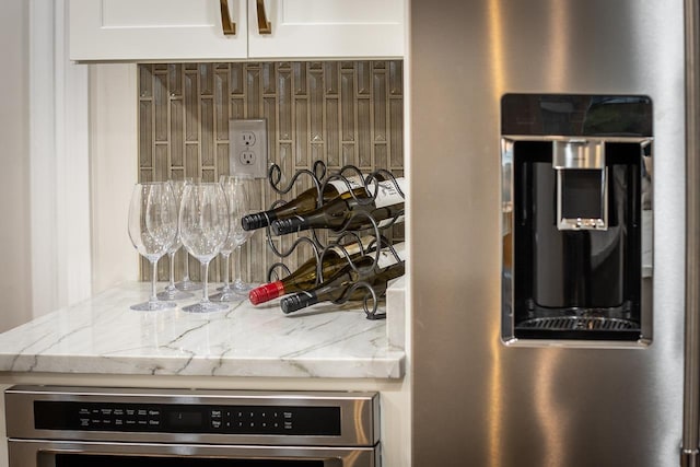 kitchen with light stone counters, white cabinets, and oven