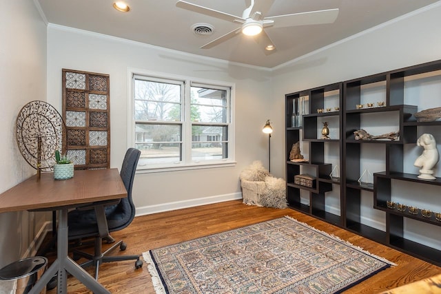 office area with baseboards, visible vents, ceiling fan, wood finished floors, and crown molding