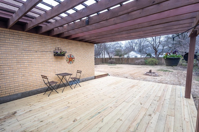 deck with an outdoor fire pit, fence, and a pergola