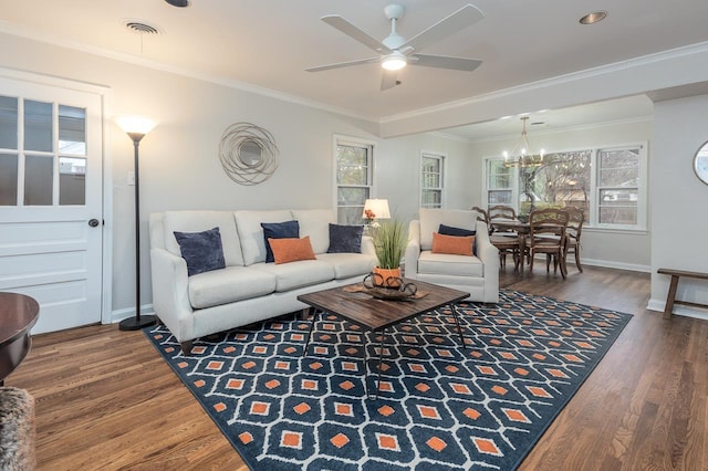 living room with baseboards, wood finished floors, visible vents, and crown molding