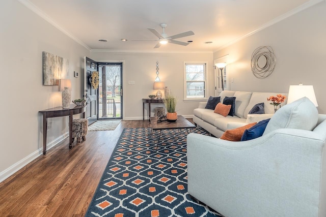 living area featuring a ceiling fan, baseboards, ornamental molding, and wood finished floors