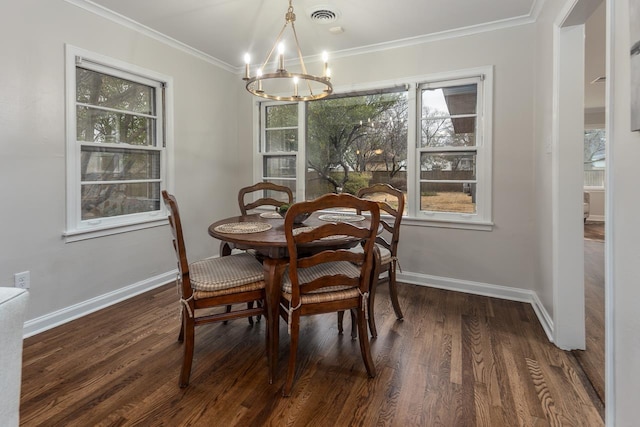 dining room with baseboards, visible vents, crown molding, and wood finished floors