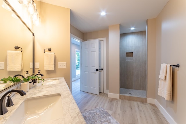 bathroom with walk in shower, a sink, and wood finished floors