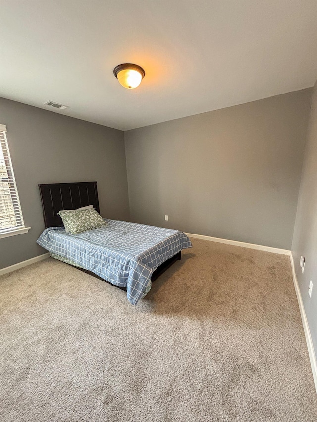 carpeted bedroom featuring visible vents and baseboards