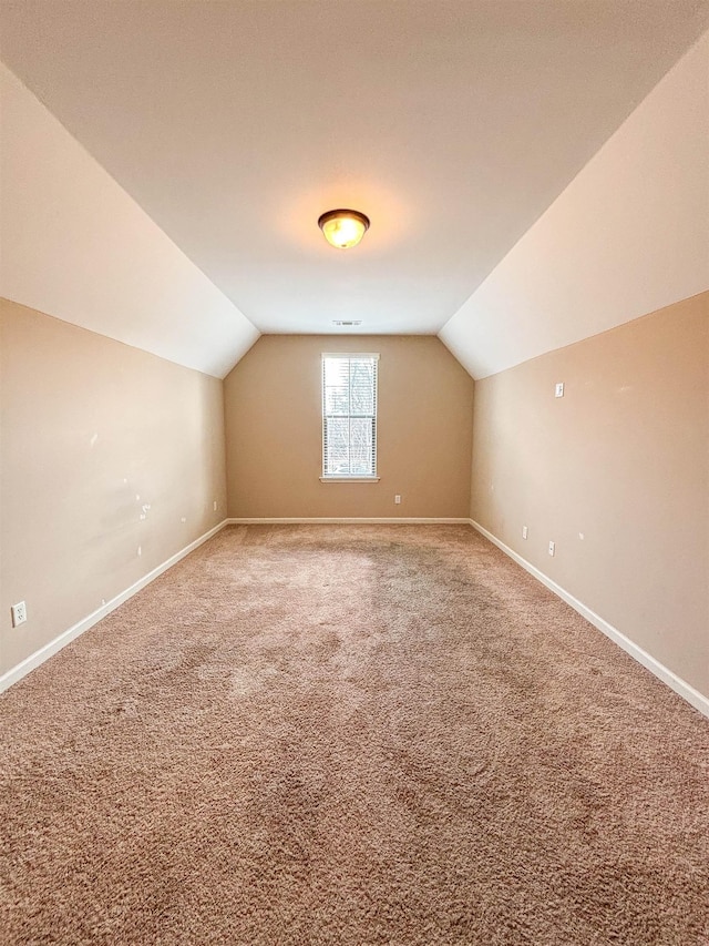 bonus room with lofted ceiling, baseboards, and carpet