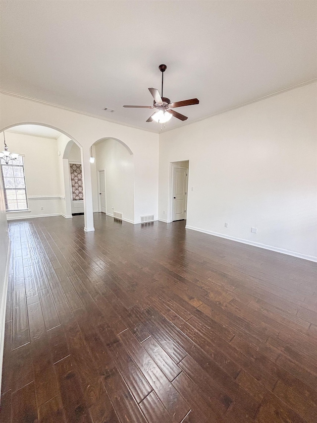 empty room featuring visible vents, dark wood finished floors, baseboards, and ceiling fan with notable chandelier