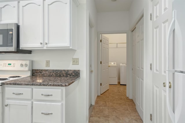 kitchen with light tile patterned floors, white appliances, washer and clothes dryer, and white cabinetry