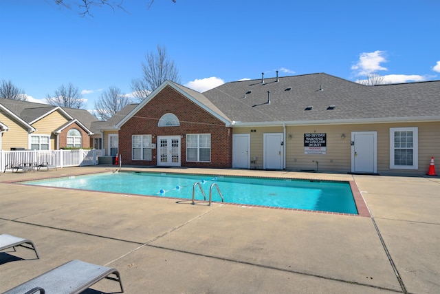 community pool with a patio, french doors, and fence