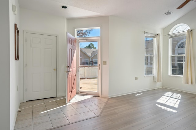 foyer entrance featuring light wood-style flooring, visible vents, and baseboards